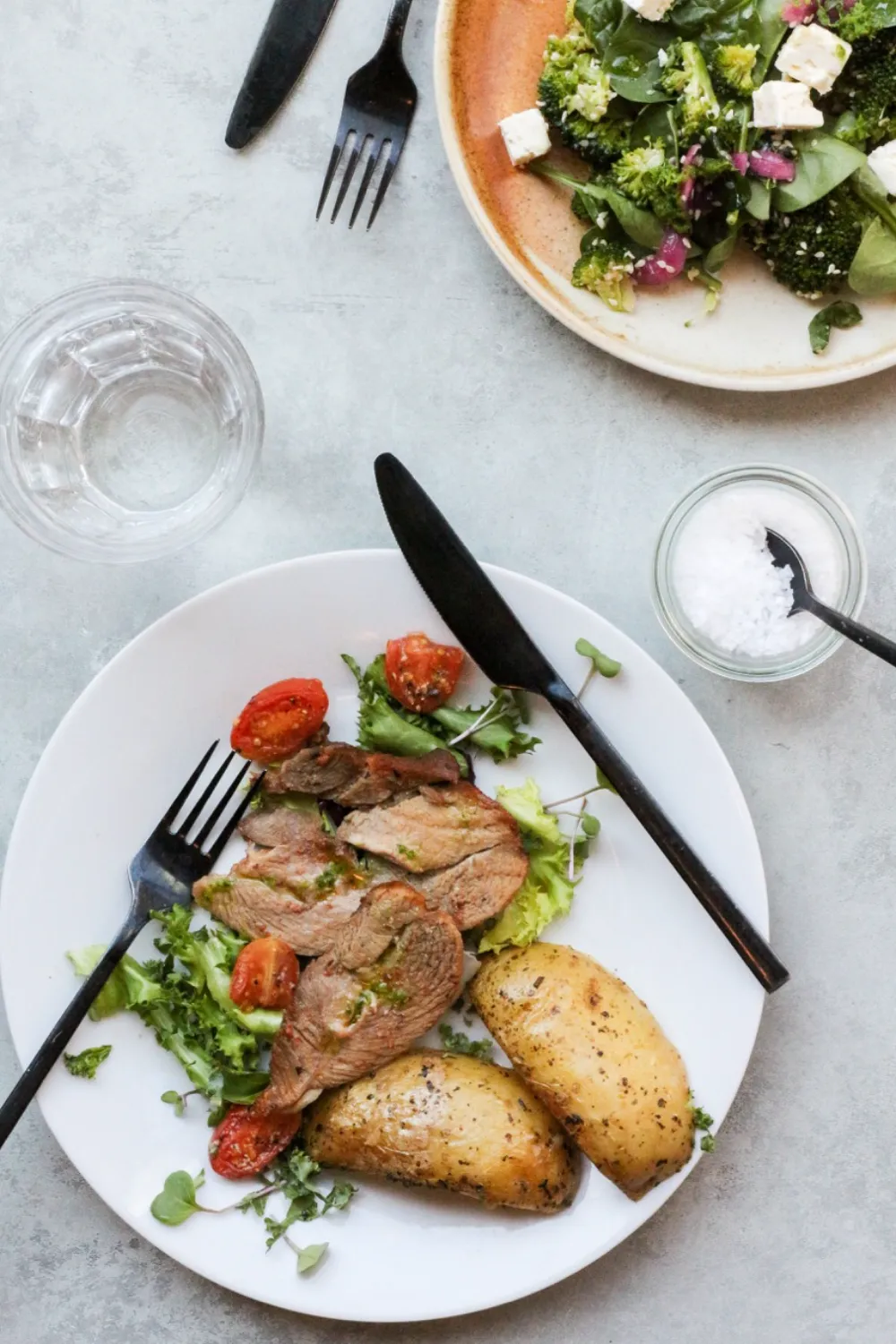 Firmafrokost Egå - Lækker tallerken med marineret kalvekød, bagte kartofler og frisk salat med cherrytomater serveret på hvid tallerken
